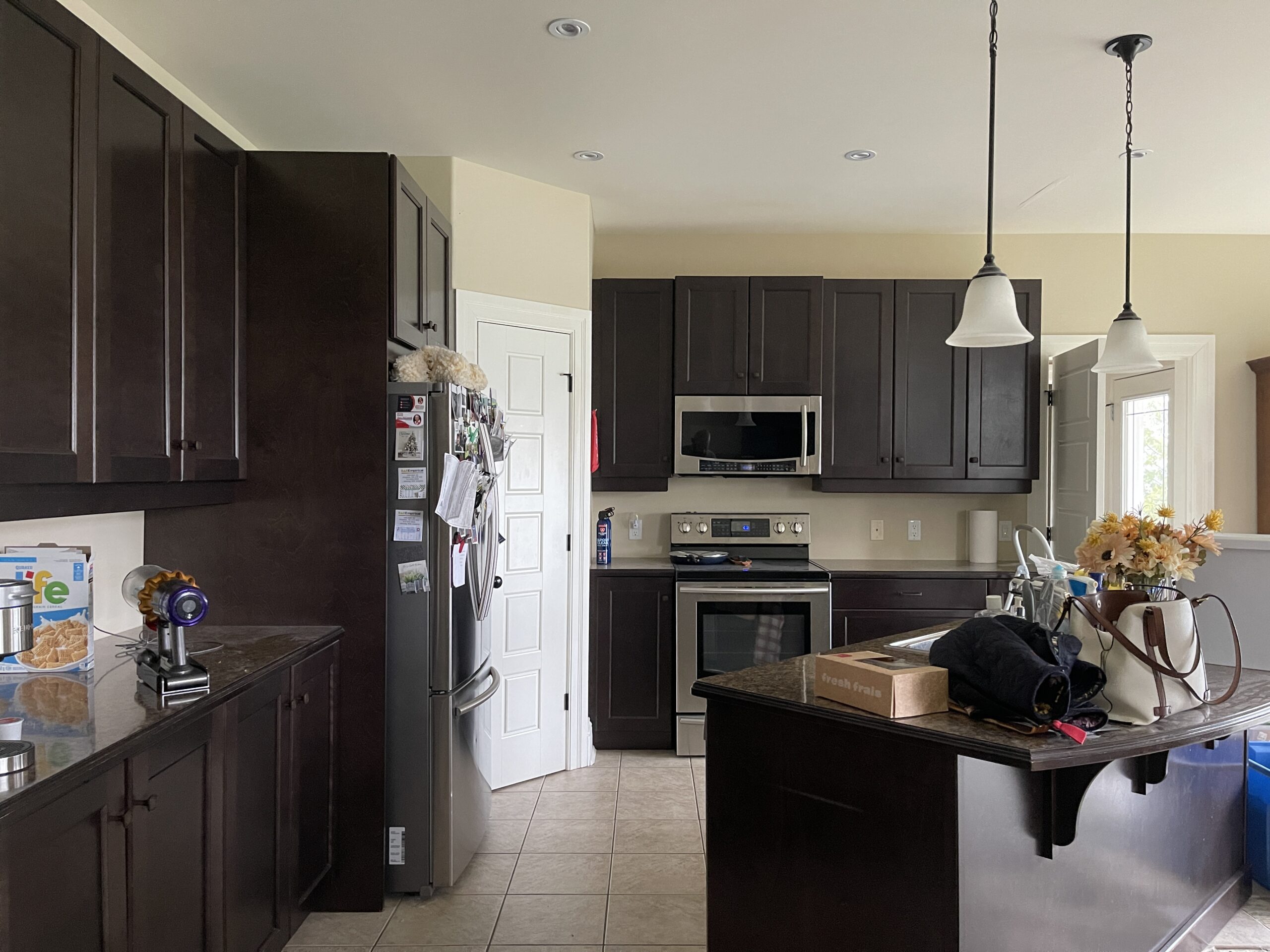 Before kitchen with dark wood cabinets, stainless steel appliances, and compact central island