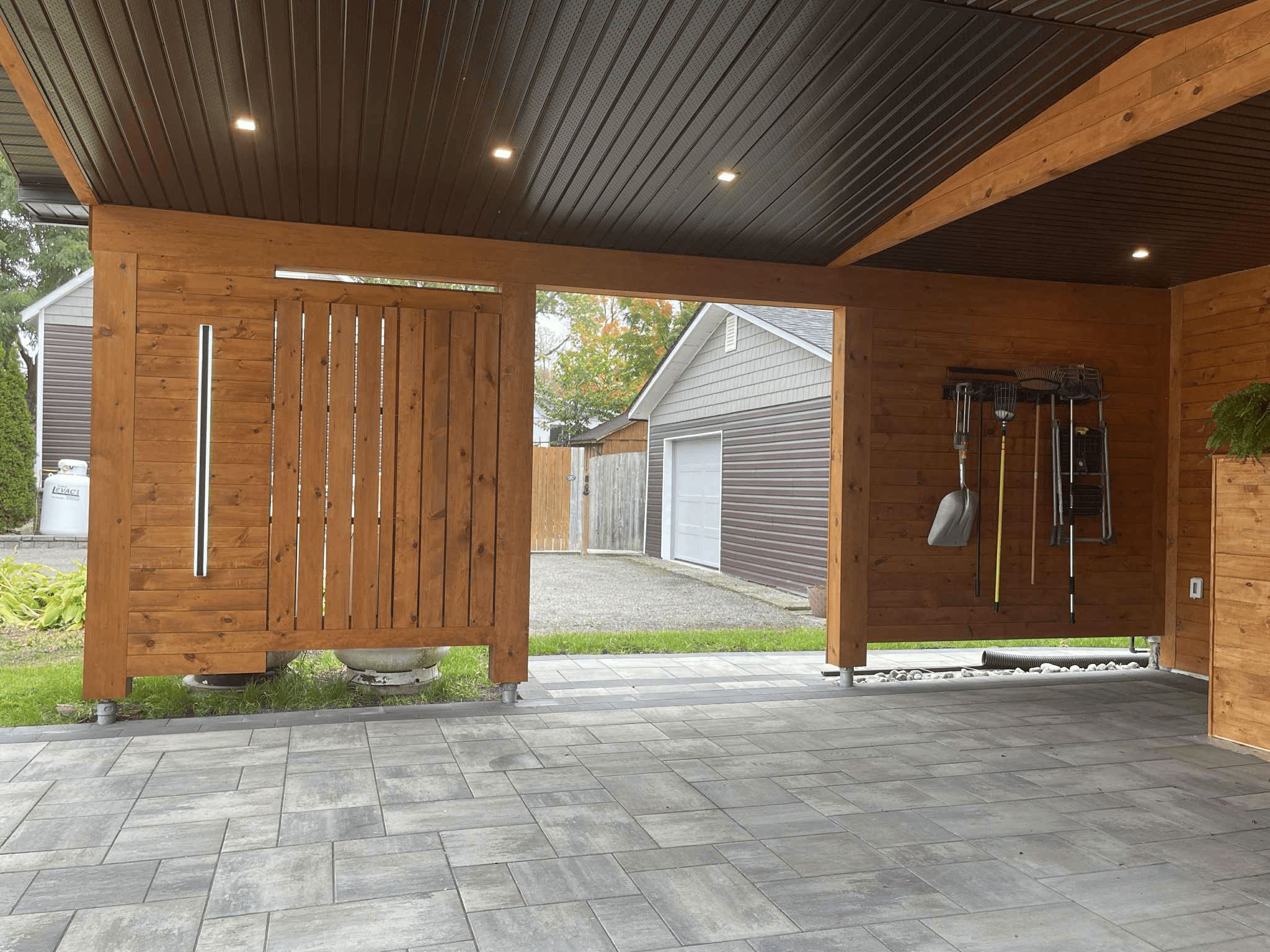 Interior left wall of cedar carport addition with vertical privacy screen and recessed soffit lighting