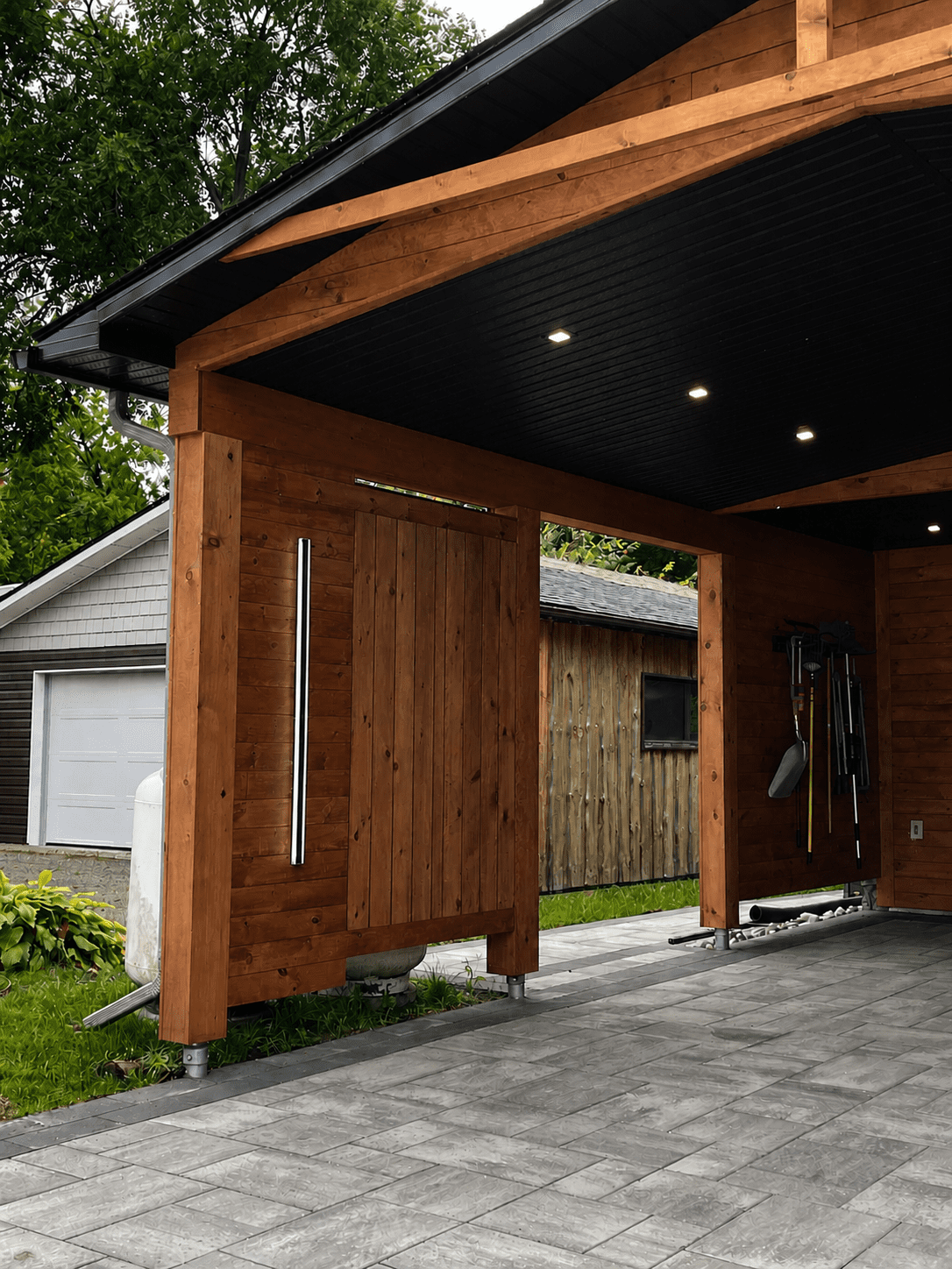 Interior right wall of cedar carport addition with privacy screen panel and integrated vertical light feature