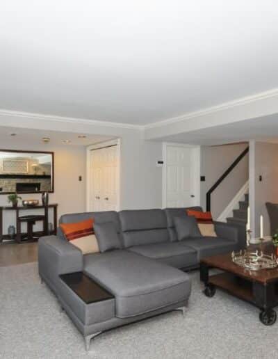 Staged basement in grey and orange by Cindy Lutes, Total Home