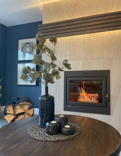 Modern fireplace insert with stone surround and accent lighting detail in a Kanata living room renovation