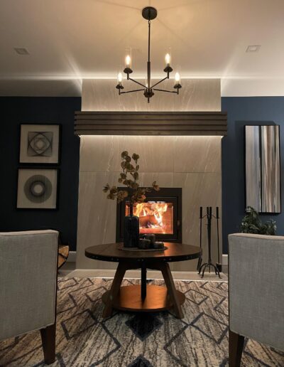 Modern fireplace feature wall with accent lighting and seating area in a Kanata living room renovation