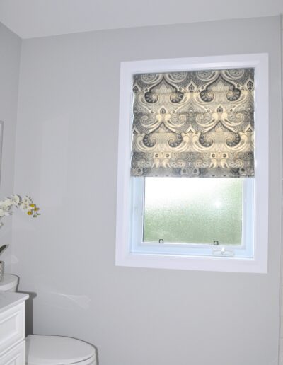 Bathroom window with patterned Roman shade in Kemptville family bathroom renovation