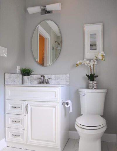 Updated Kemptville family bathroom with white vanity, round mirror, and modern fixtures