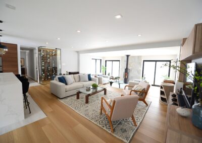 Open-concept living space with wine wall, sunroom, and contemporary seating arrangement.