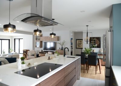 Modern kitchen island with induction cook-top, pendant lighting, and open view to dining area.