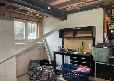 Basement laundry window wall before renovation with temporary storage and exposed ceiling in Kemptville
