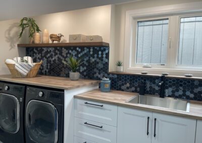 Custom laundry cabinetry with integrated appliances and wood counters in Kemptville home renovation