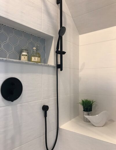 Shower niche with hex tile accent and black fixtures in Kemptville renovation