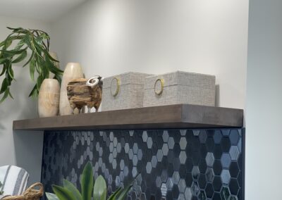 Floating wood shelf with decorative storage boxes above laundry back-splash in Kemptville design build project