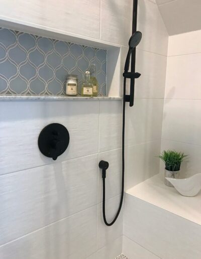Shower niche with patterned accent tile and black fixtures in Kemptville renovation