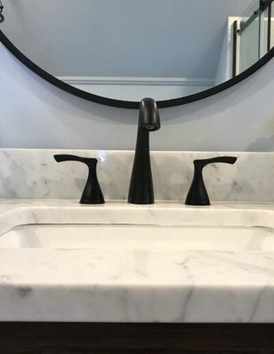 Bathroom vanity with marble countertop and black faucet in Kemptville renovation