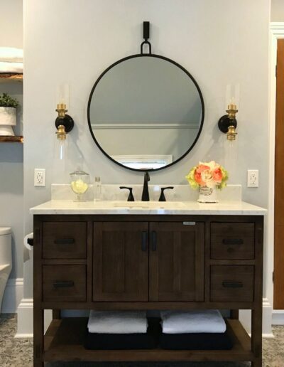 Dark wood vanity with round mirror in Kemptville bathroom renovation