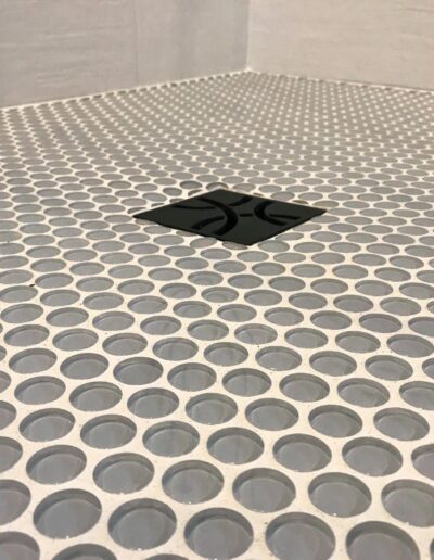 Penny tile shower floor with black drain detail in Kemptville bathroom renovation