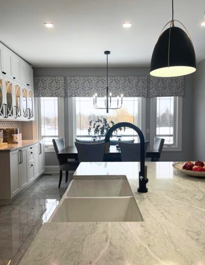 Modern farmhouse kitchen sink with quartz countertop, black faucet, breakfast area windows, and custom window valances