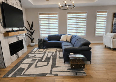 Modern minimalist living room with navy sectional, marble fireplace, and contemporary furnishings in Hallville Ontario.