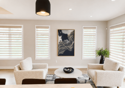 Contemporary sitting area with neutral accent chairs, artwork, and minimalist styling in Hallville Ontario home.