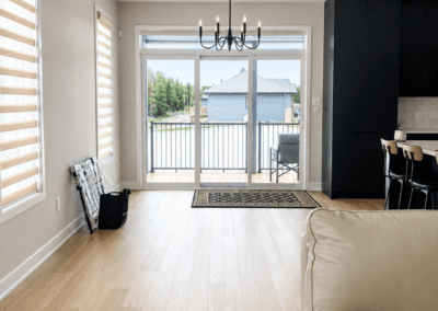 Minimalist open-concept living space with empty floors and sliding patio doors before furniture selections.